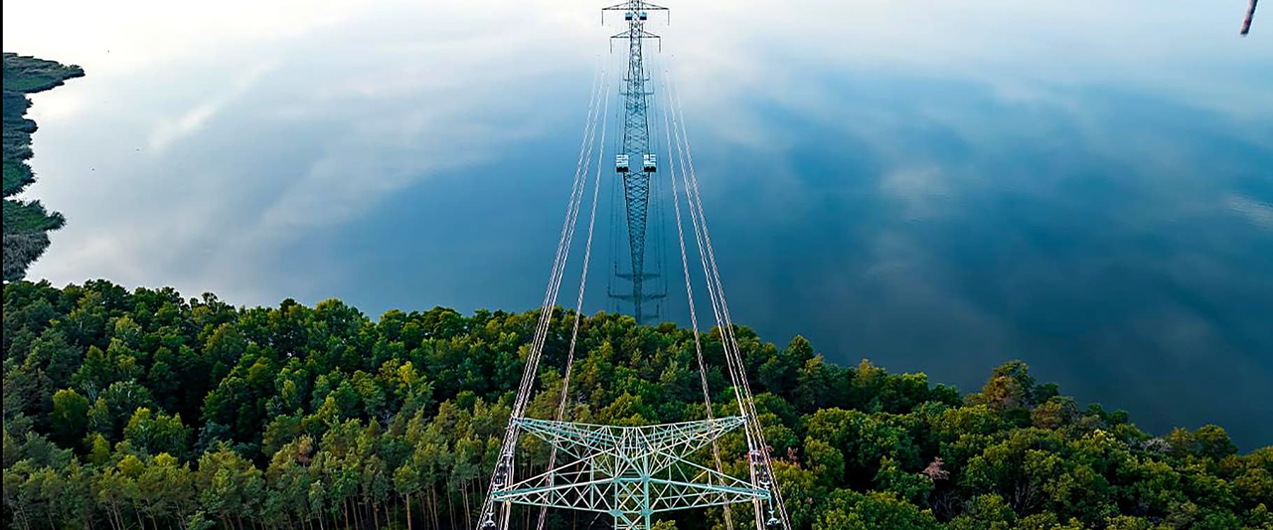 Transmission tower reflected in a lake
